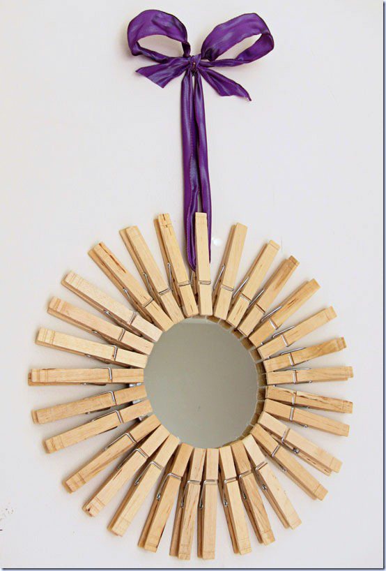DIY Starburst mirror hung on wall with purple ribbon