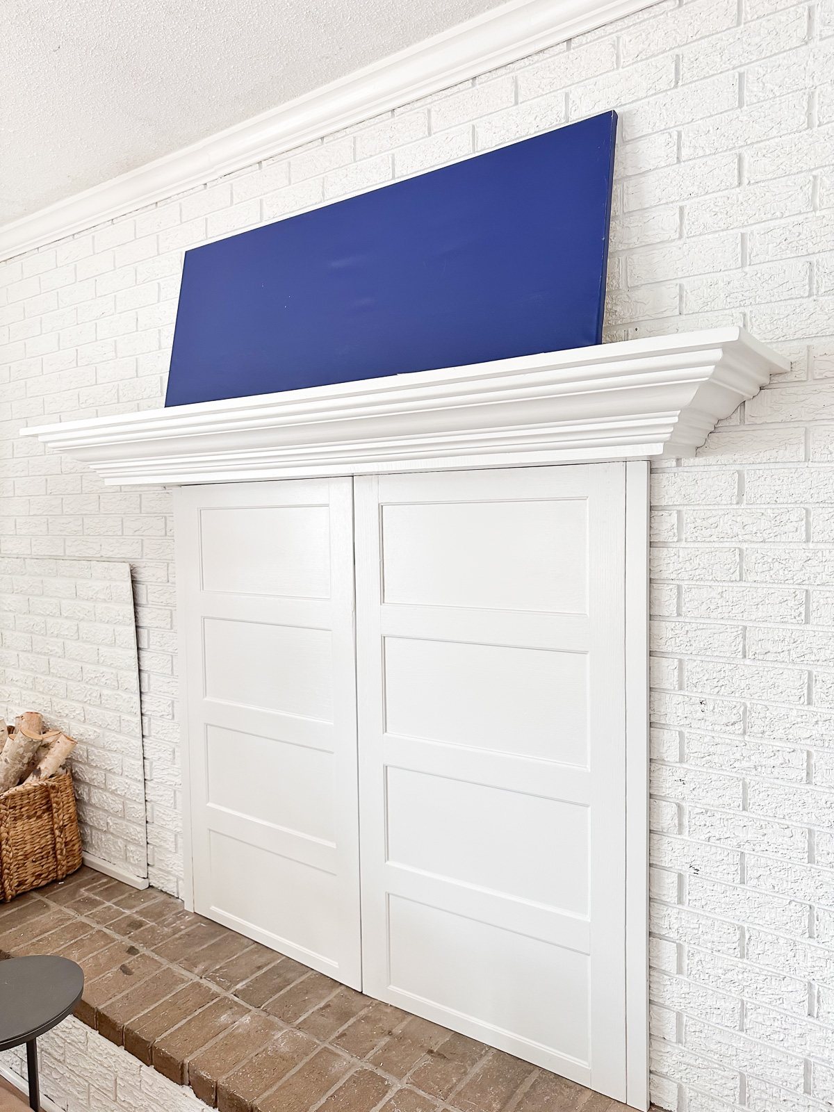 side view of a white brick fireplace wall and mantel without anything on it.