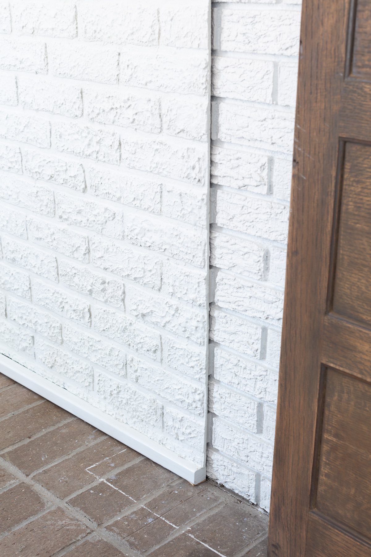 close up of faux brick paneling with spackle added to provide texture to match brick wall around it.