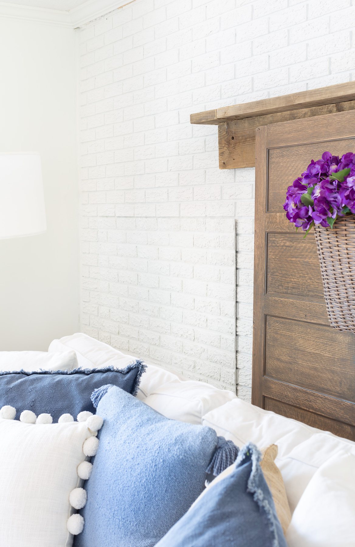 Side view of faux brick paneling used to cover up a firewood storage area for the summer on a brick accent wall in a living room.