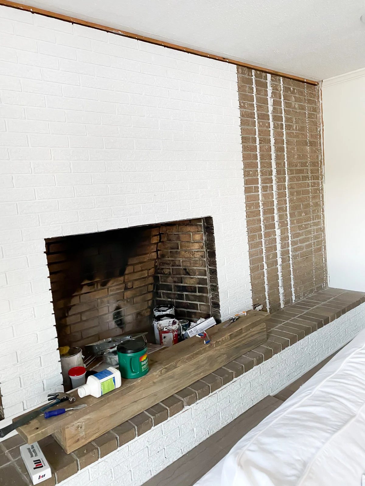 fireplace wall getting a coat of white paint
