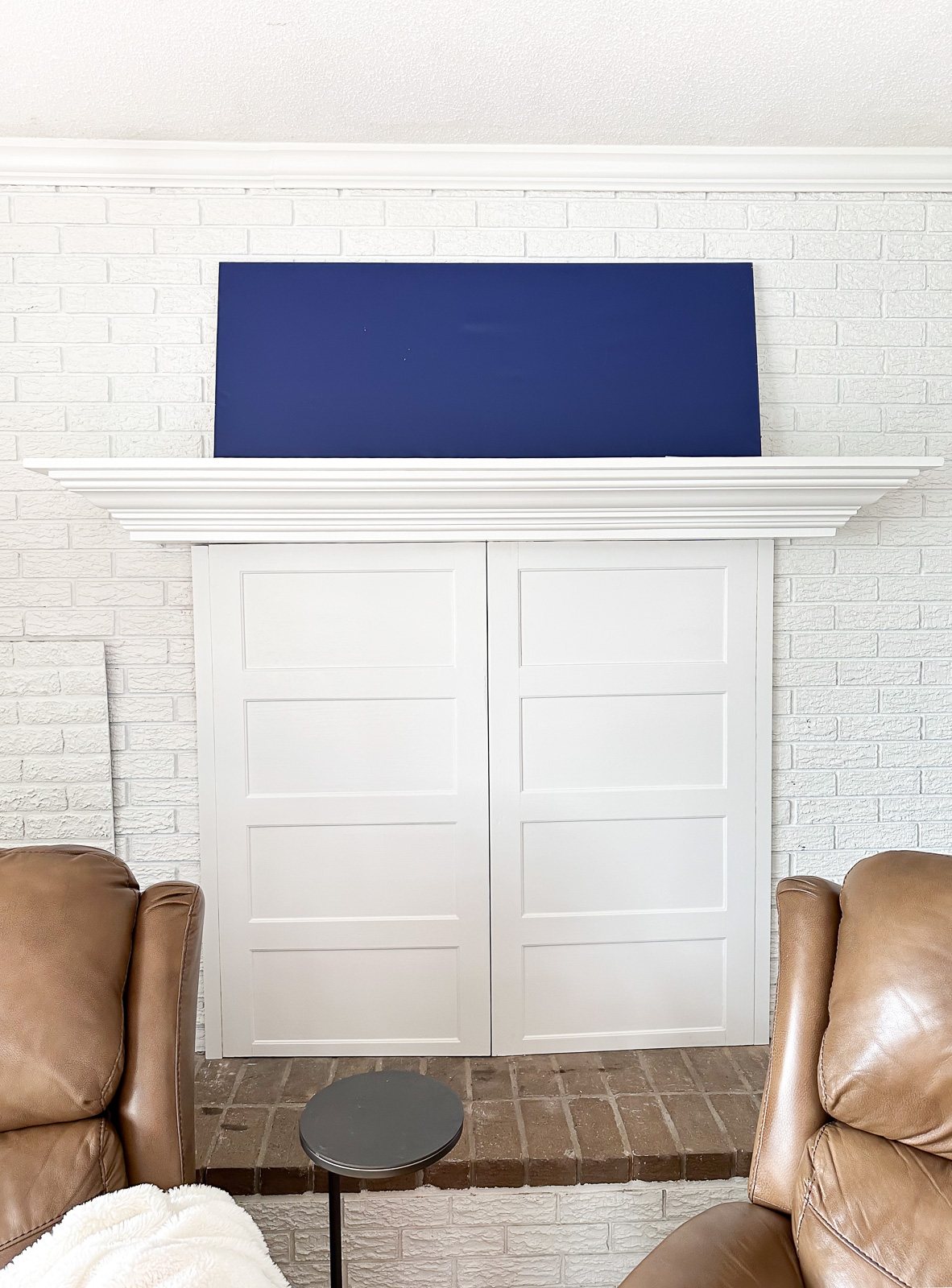 face on view of a white brick fireplace wall and mantel without anything on it.