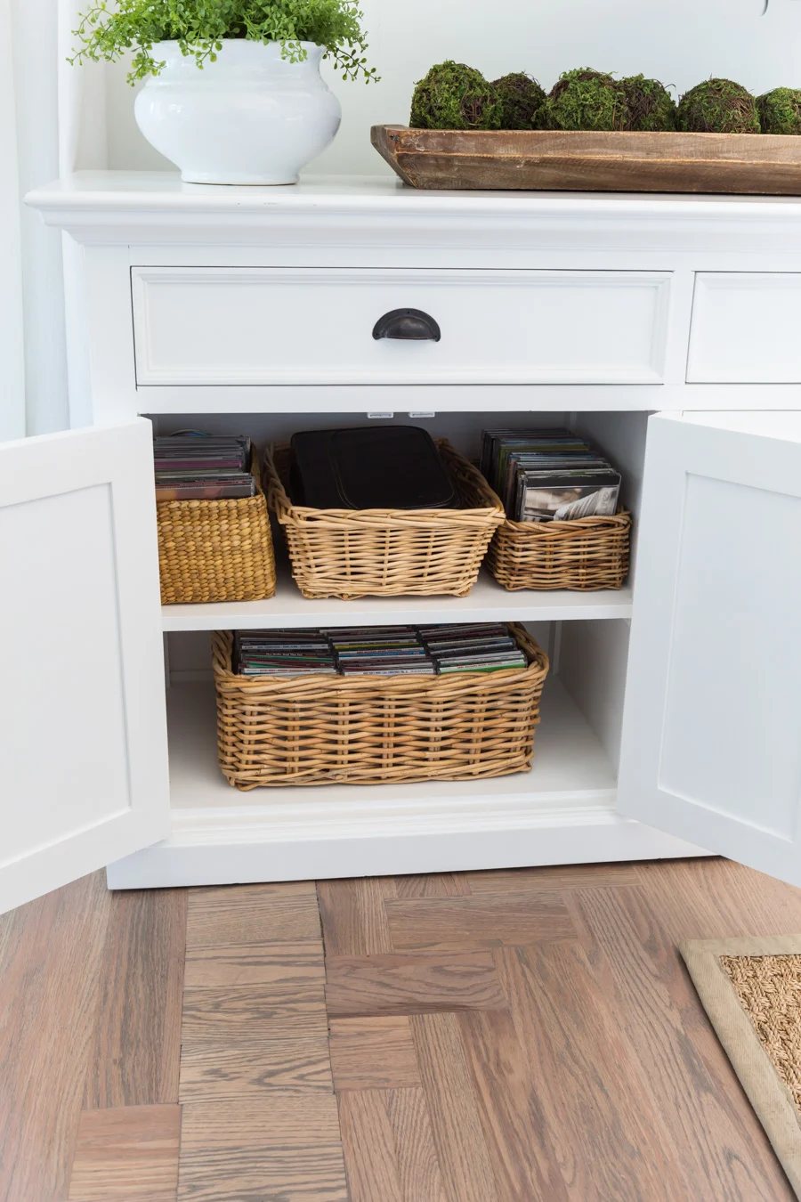 Storage baskets in a sideboard cabinet.