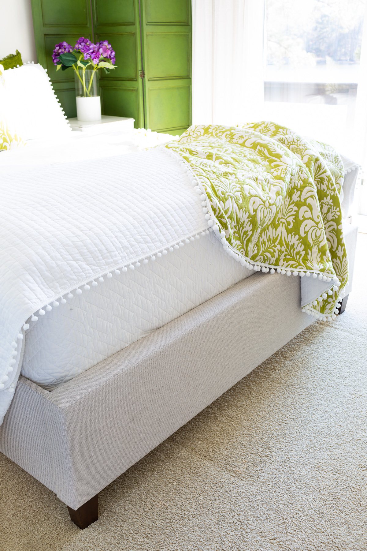 Christeli mattress in an Eastman platform bed with white bedding and a green and white throw blanket
