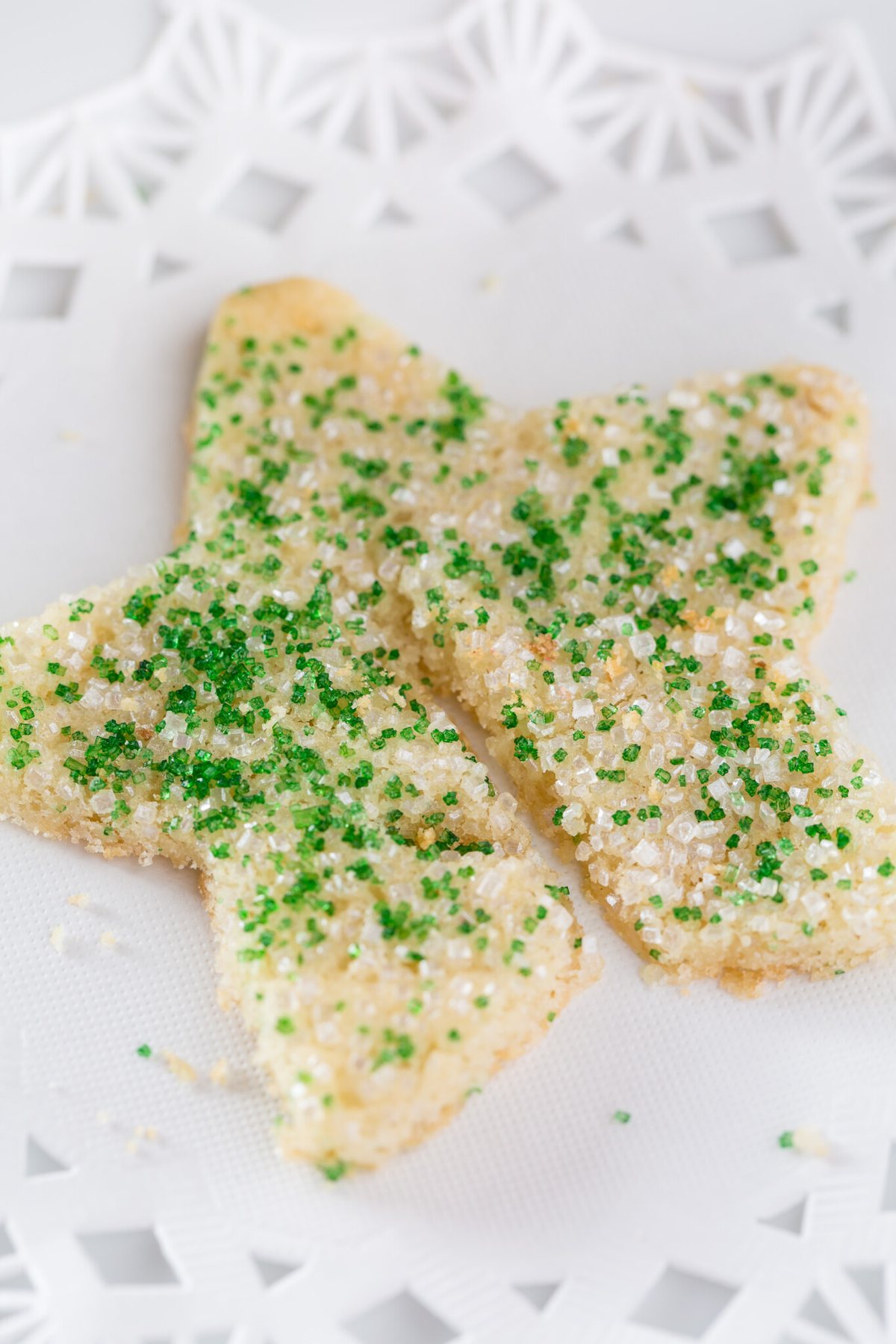 Star shaped Christmas sugar cookie with green and white sprinkles on top.