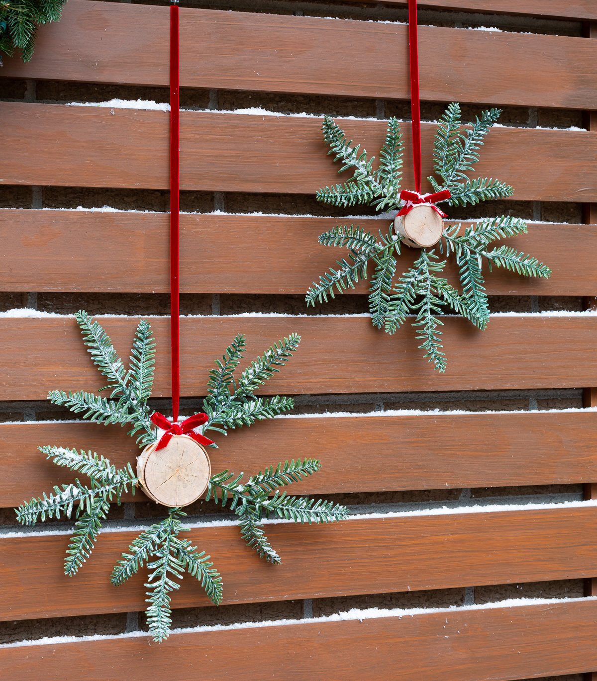 Two Christmas wreath alternatives hanging on a home's exterior.