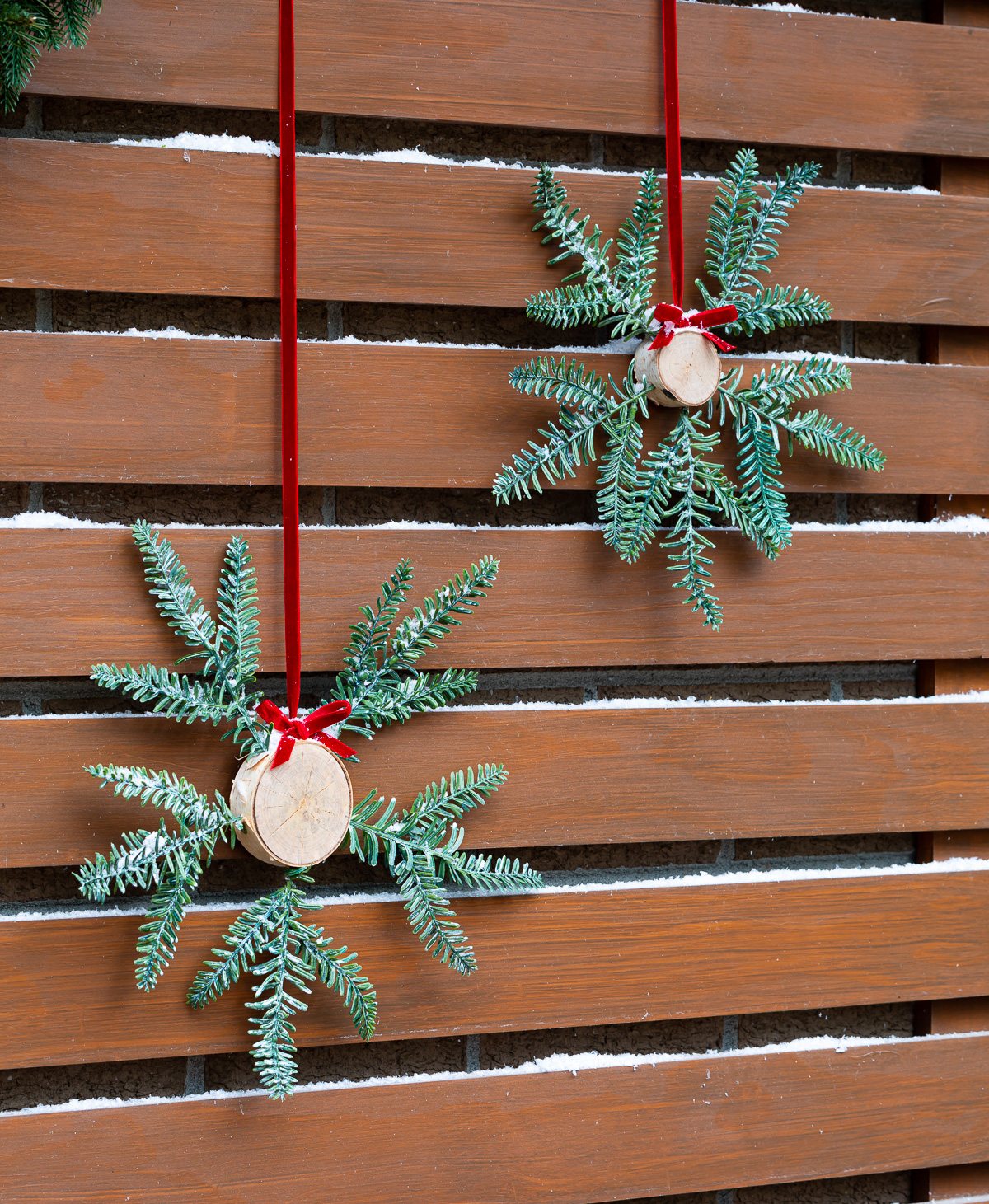 Two Christmas wreath alternatives hanging on a home's exterior.