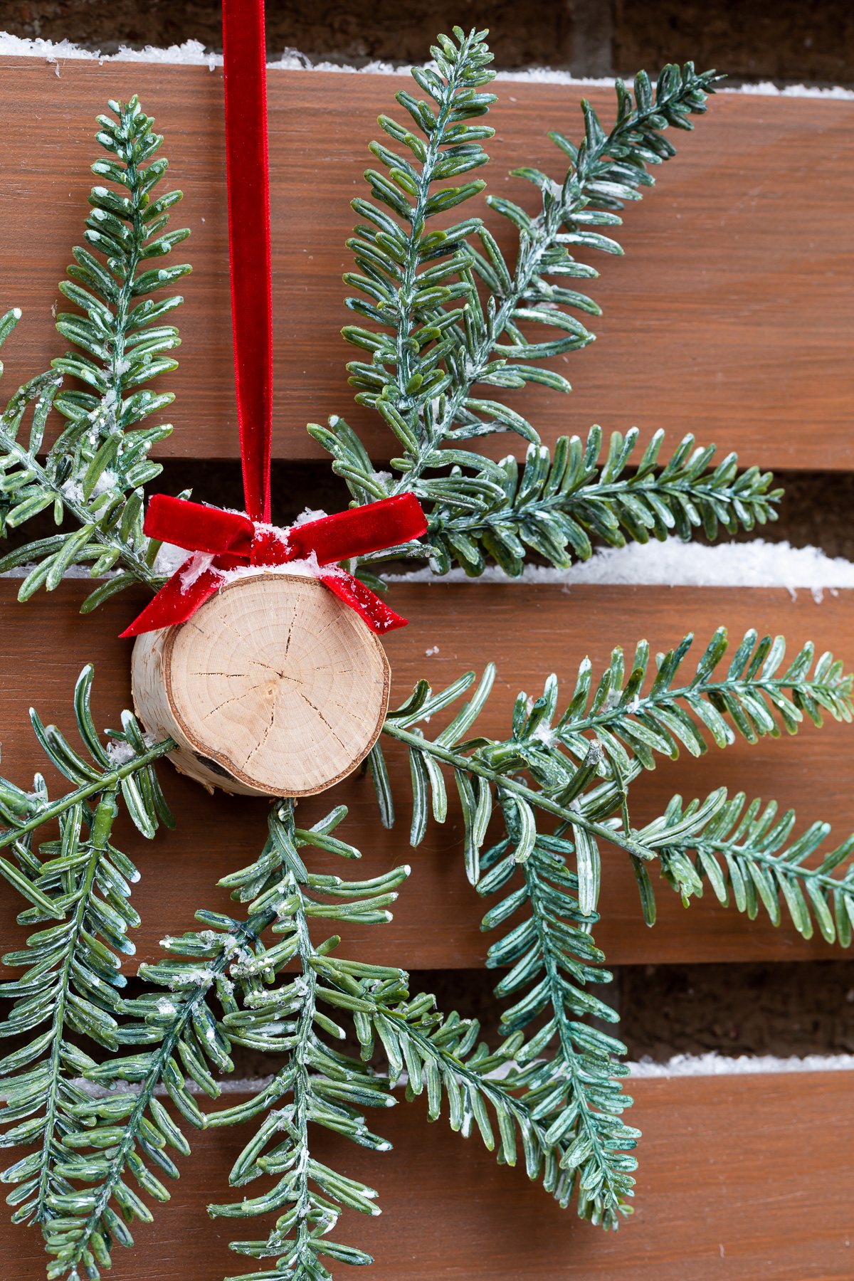 Homemade Christmas wreath idea using a slice of tree trunk and pine branches.