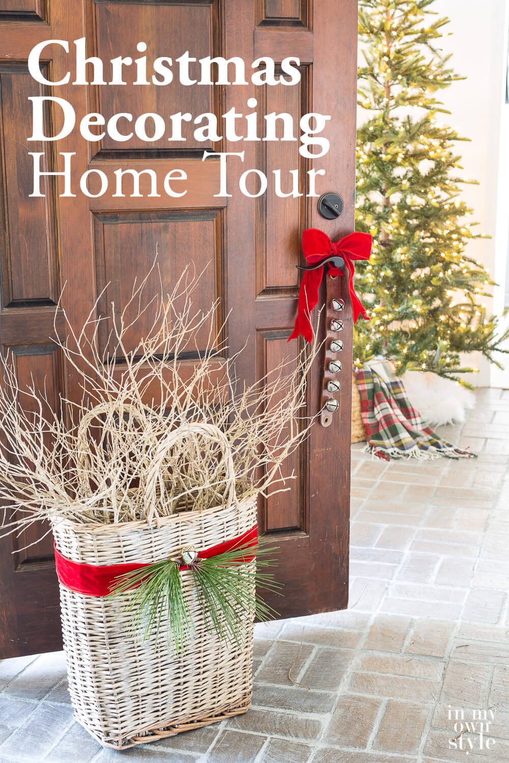 Foyer door open with red ribbon tied sleigh bells and basket. Text overlay says Christmas decorating home tour