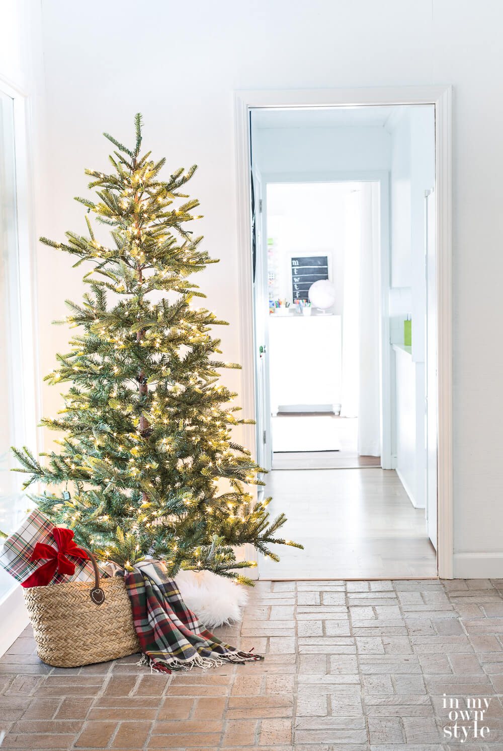 Christmas tree with white twinkle lights in foyer.