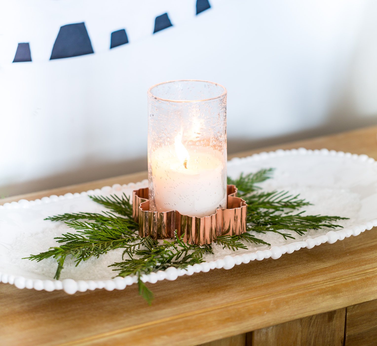 Candle placed inside a copper snowflake cookie cutter on a tray of salt makes for easy to do last minute Christmas decorating