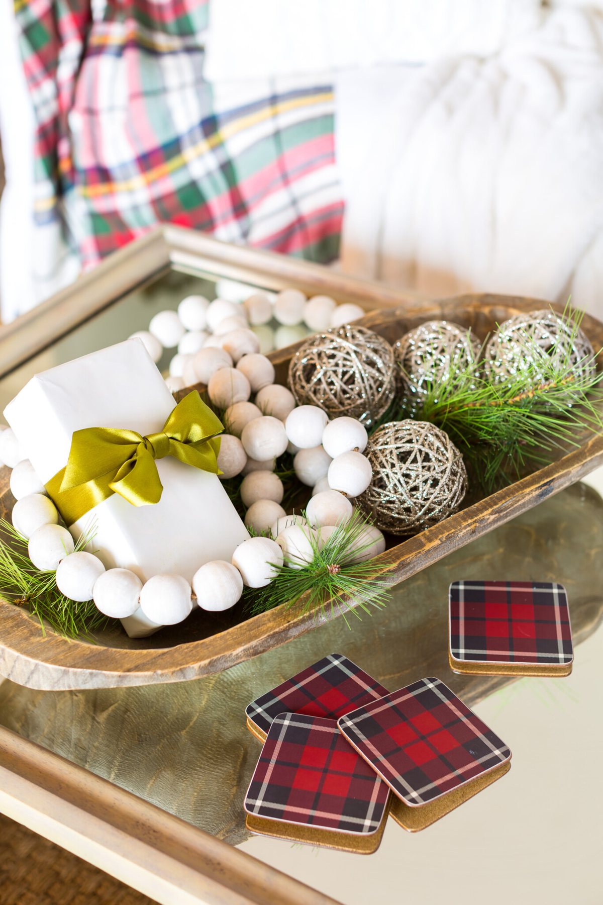 Large dough bowl on table decorated for Christmas.