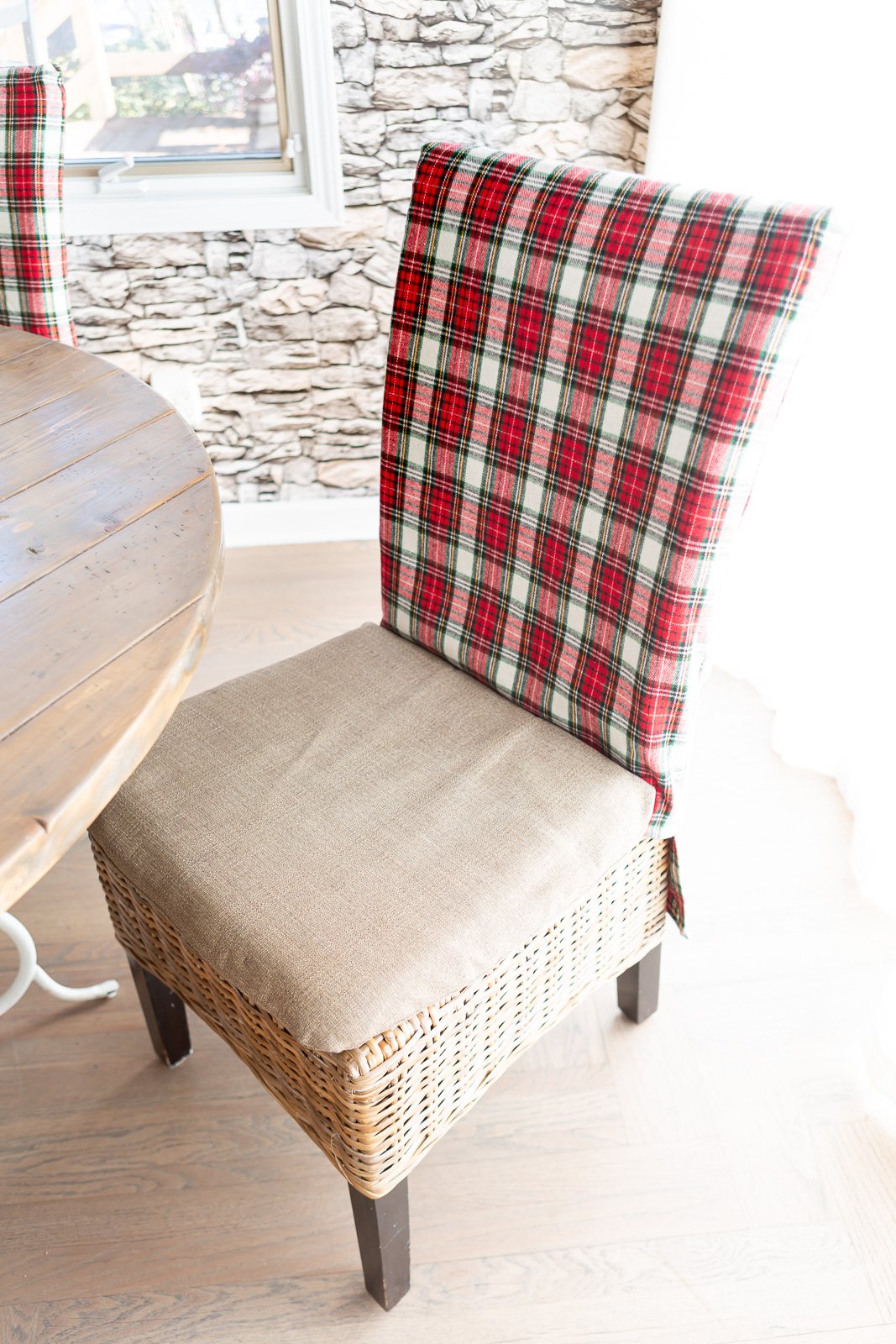 a Christmas fabric covered dining chair pulled back away from the dining table.