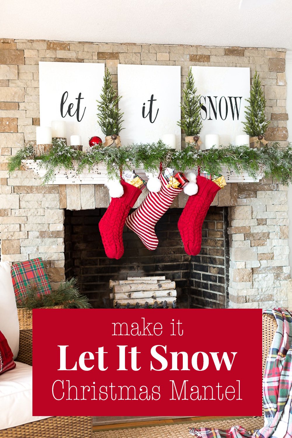 A white mantel on a stone fireplace decorated with white signs that say Let it Snow