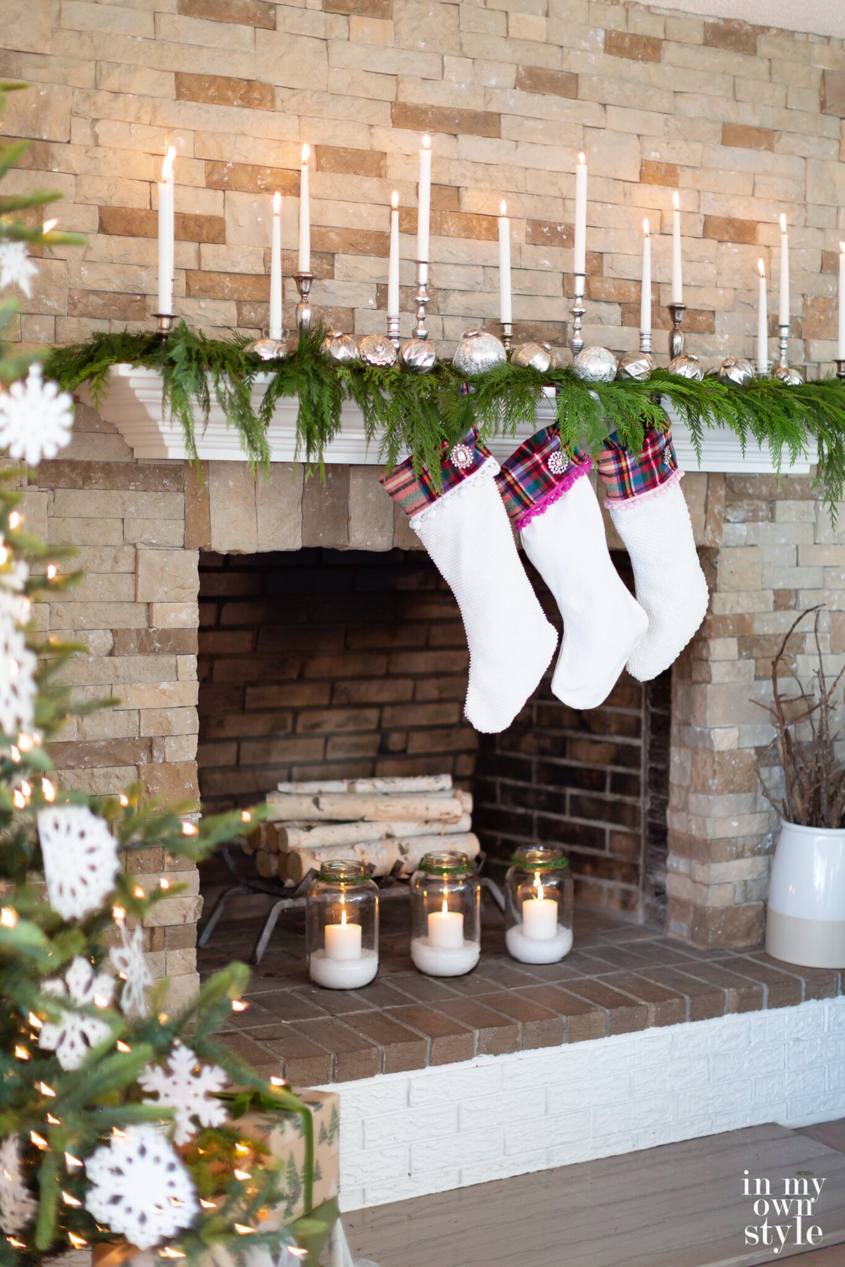 Candle filled fireplace mantel decorated for the holidays