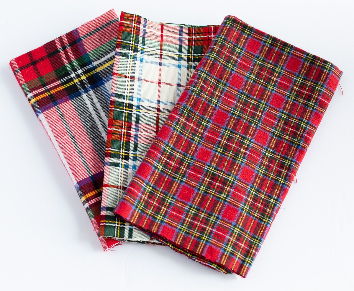 3 red plaid fabrics made into dinner table napkins.