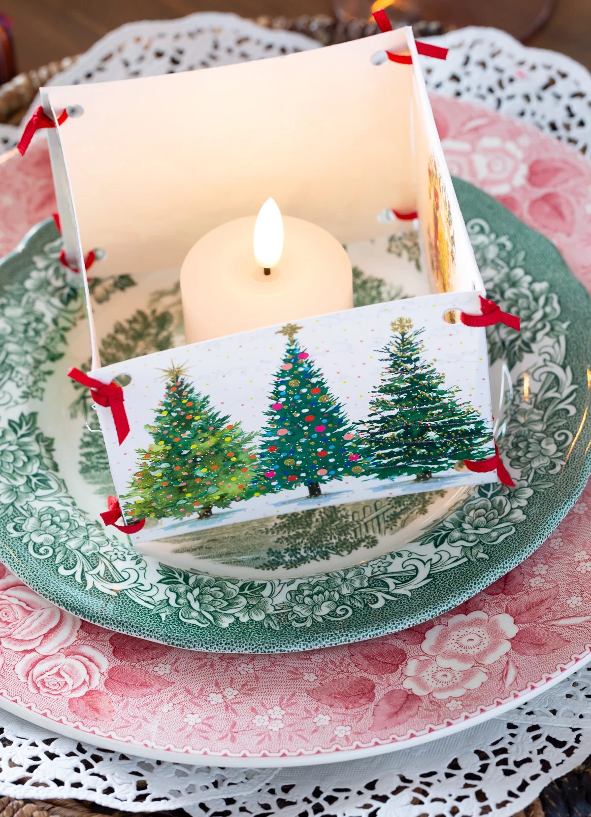 Candle placed inside a box made of old Christmas cards