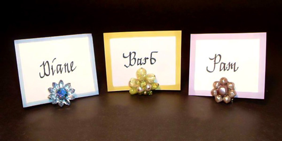 3 place cards using vintage clip on earrings as place card holders.