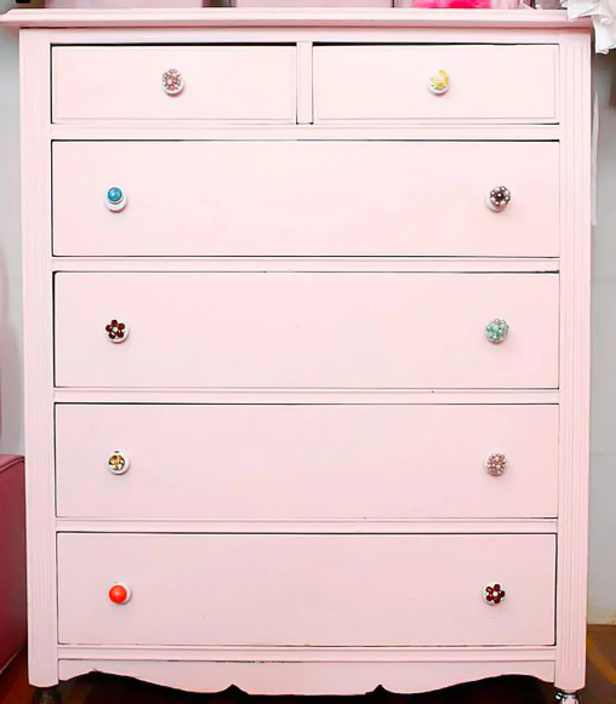 pink chest of drawers with vintage clip on earrings as drawer pulls.