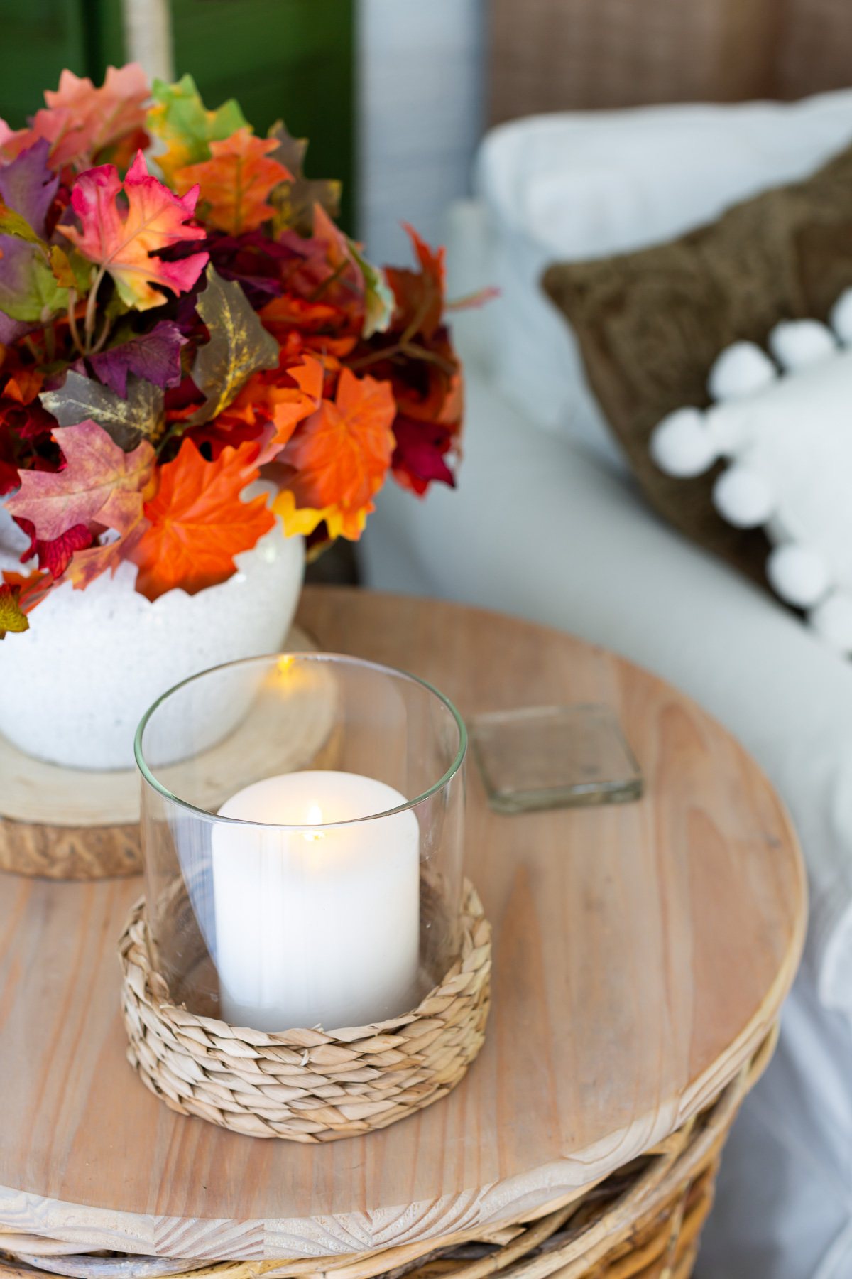 hyacinth hurricane candle holder on round wood wicker side table
