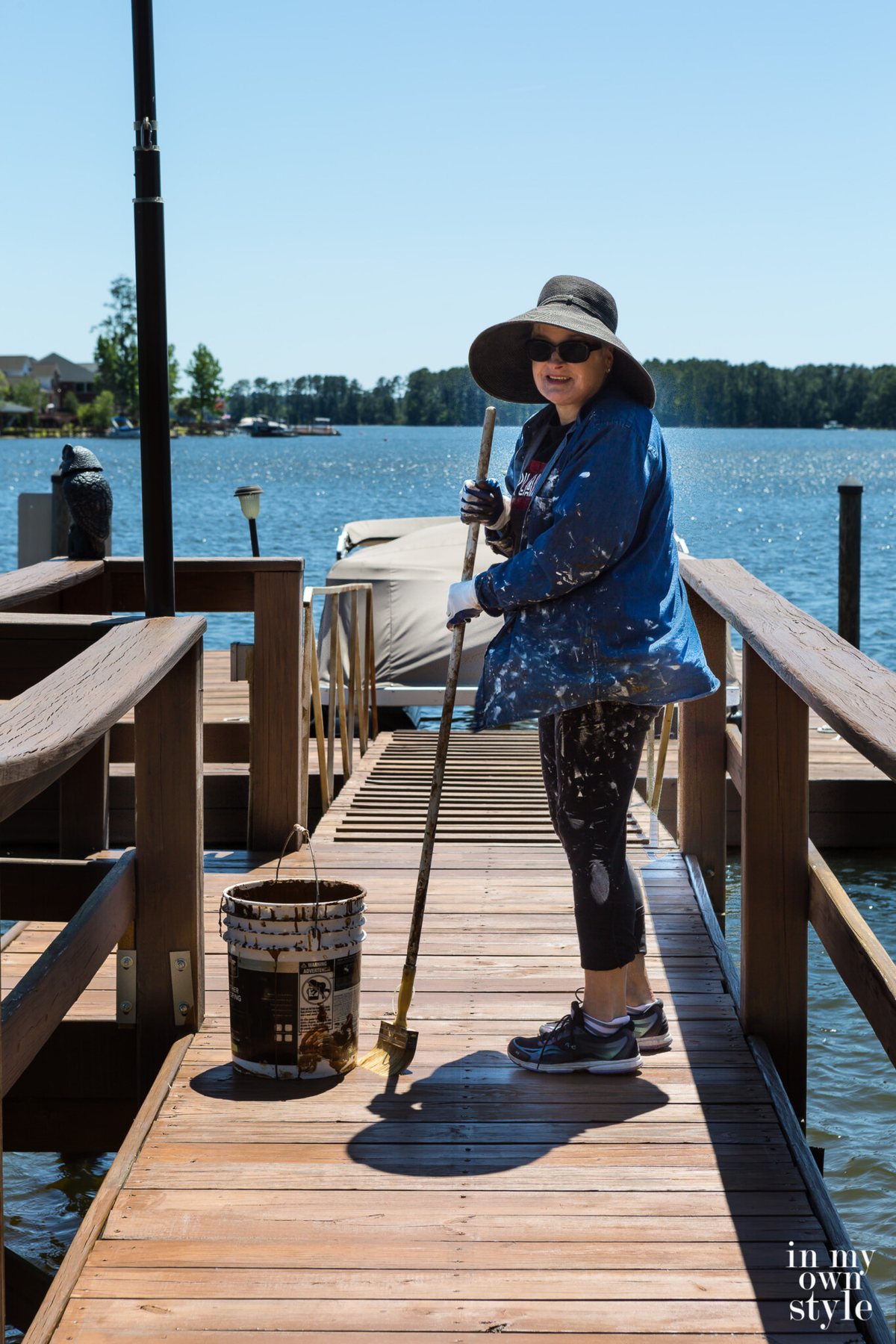 Diane with hat and sunglasses Staining the dock on Lake Murray