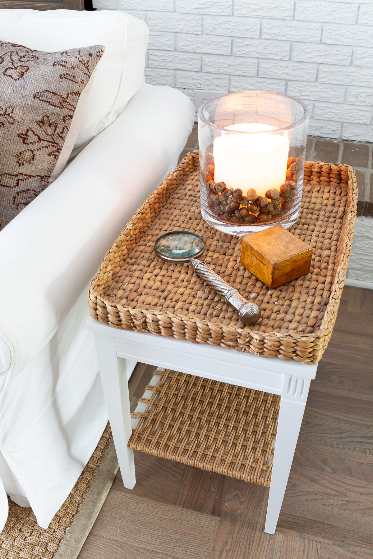 Woven tray side table in living room decorated for fall.