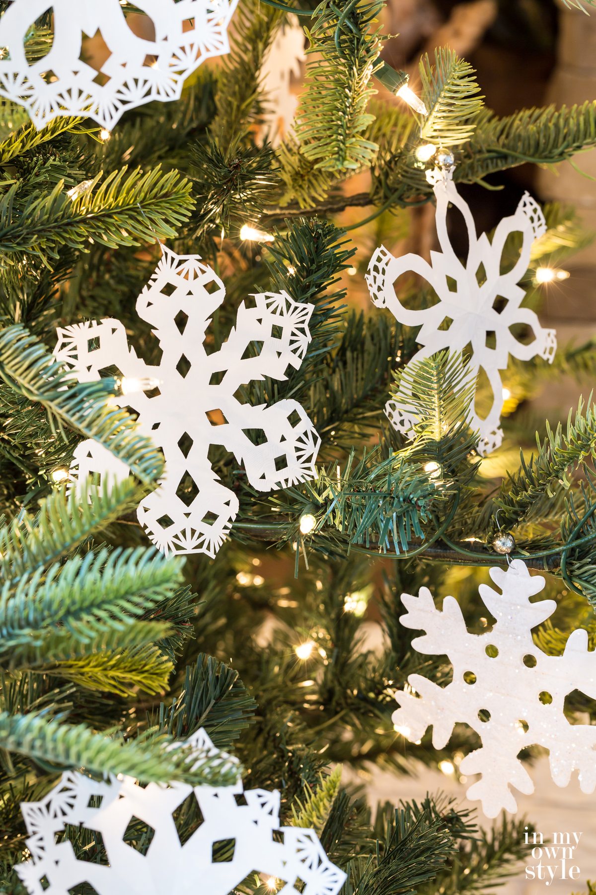 Paper Snowflakes hanging on a Christmas tree made using paper doilies