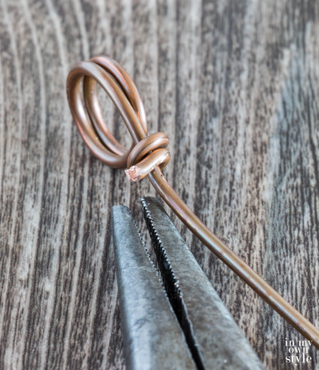 Use point nose pliers to bend electrical wire into a two circles.