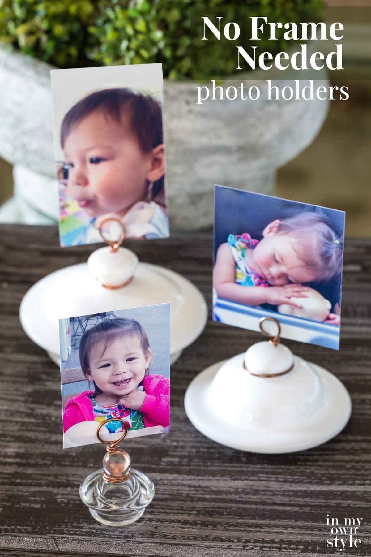 3 lid photo holders made with teapot and other lids with photos on display on a table. Text overlay says No Frame Needed photo holders.