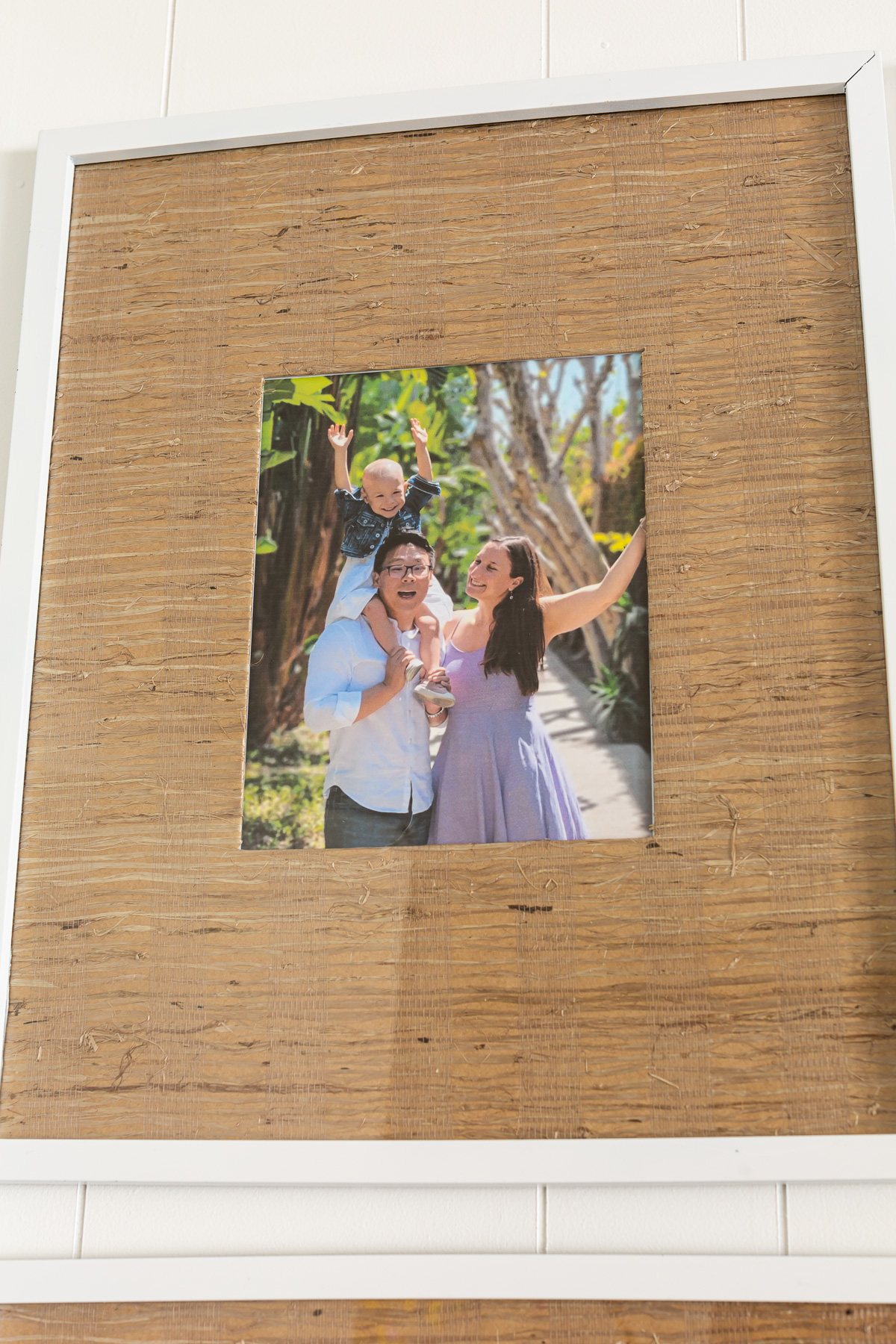 color photo of family in grasscloth wallpaper matted picture frame.