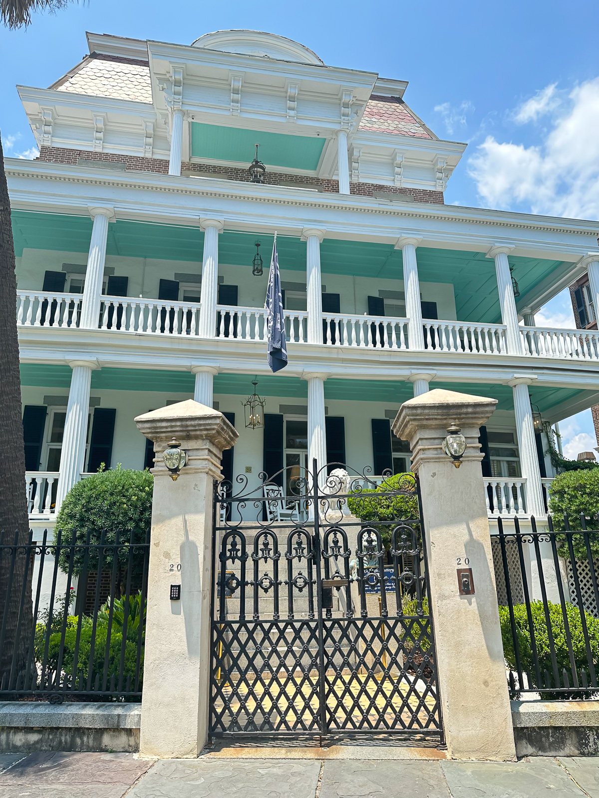 a teal and white historic southern mansion overlooking the harbor in Charleston