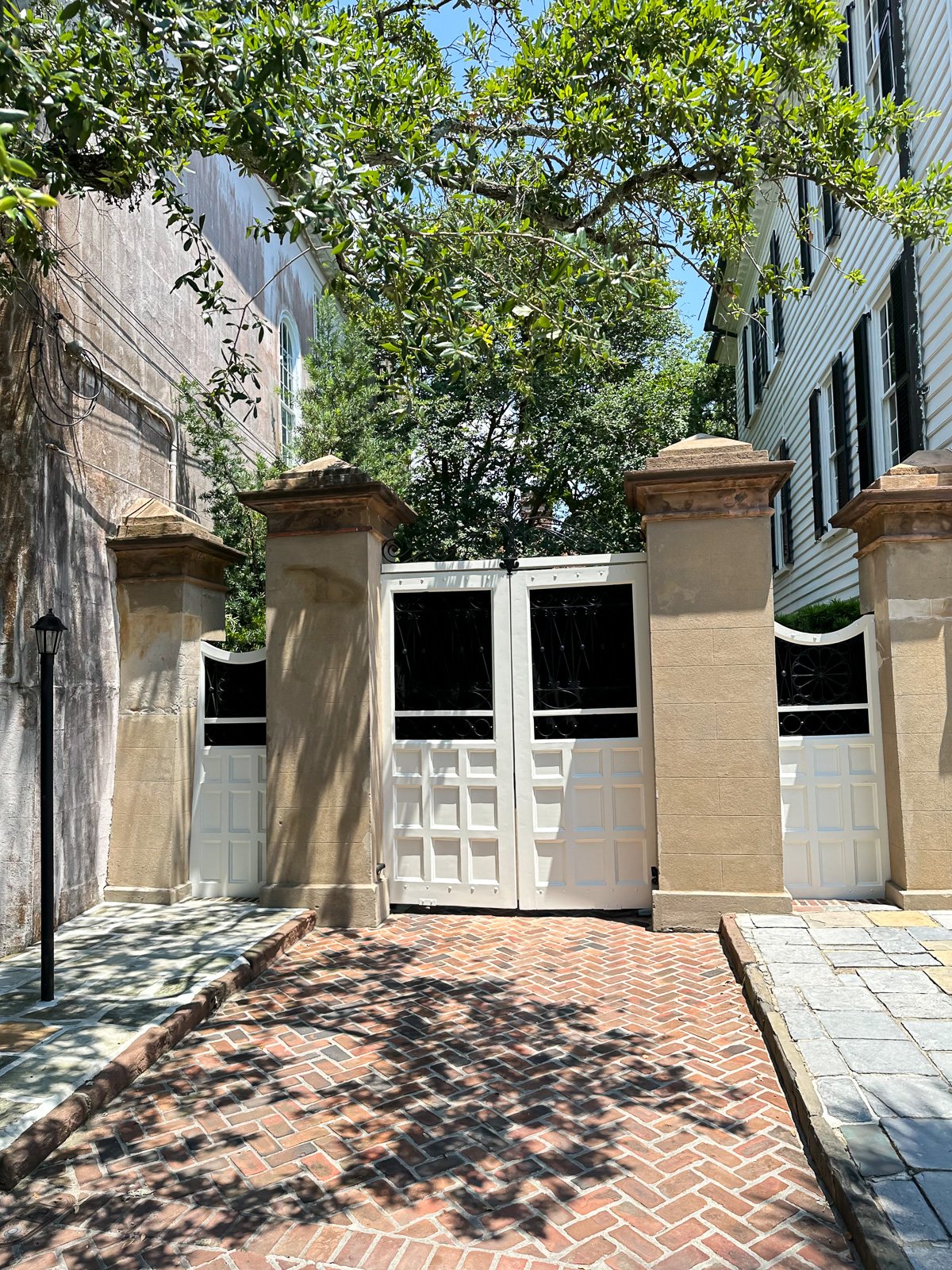 White wood driveway door flanked by stucco square columns.