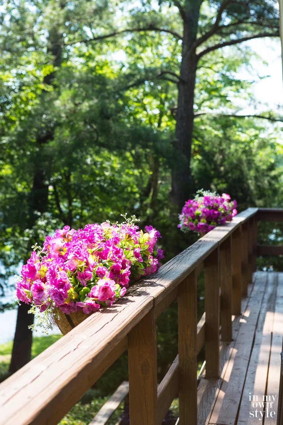 Window box flower planters with fake flowers on deck railing.