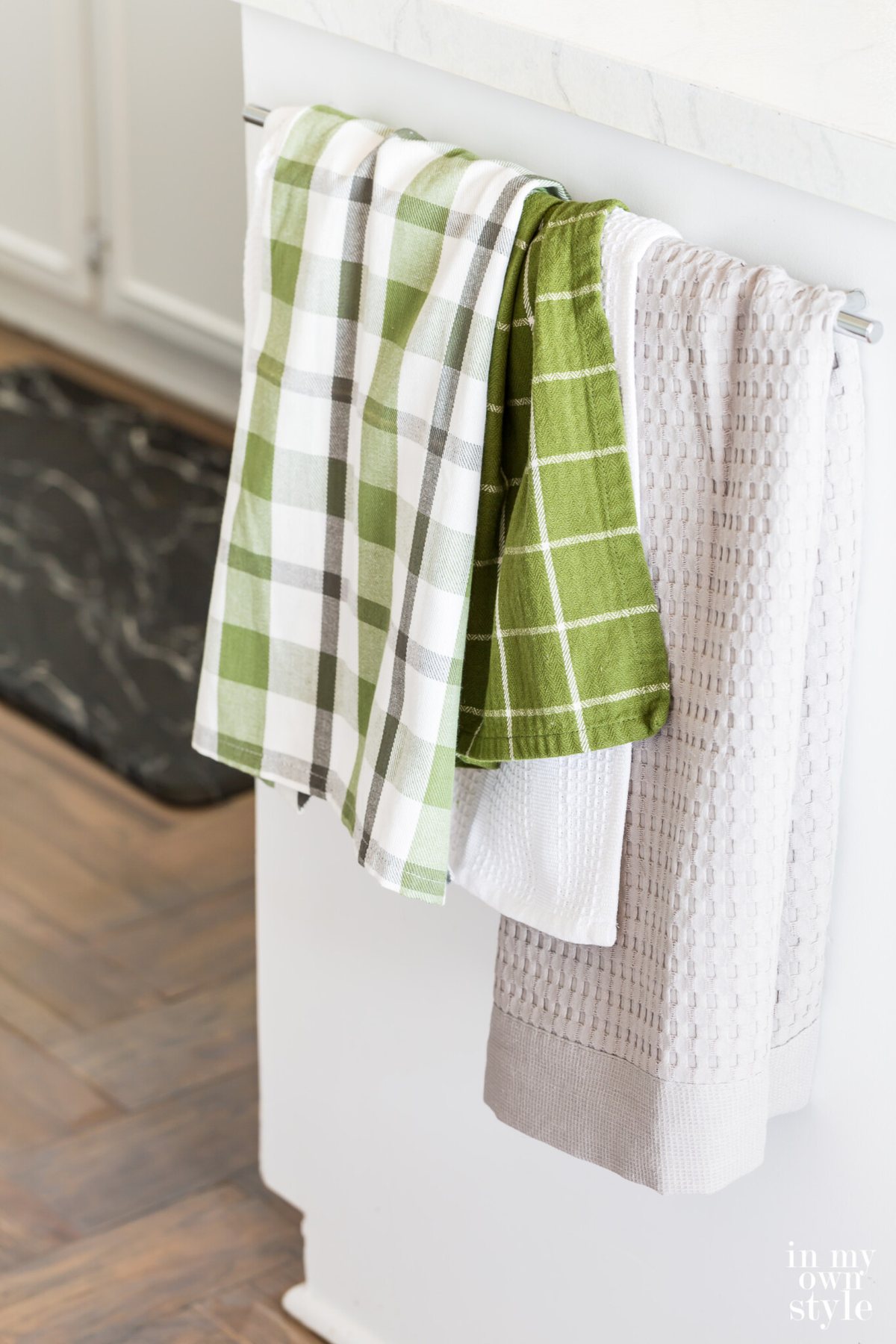Dishtowels hanging from towel bar in summer decorated kitchen.