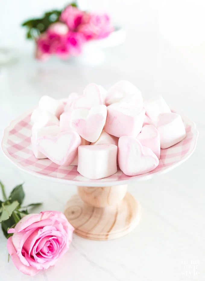 heart marshmallows on top of a pink and white checked plate