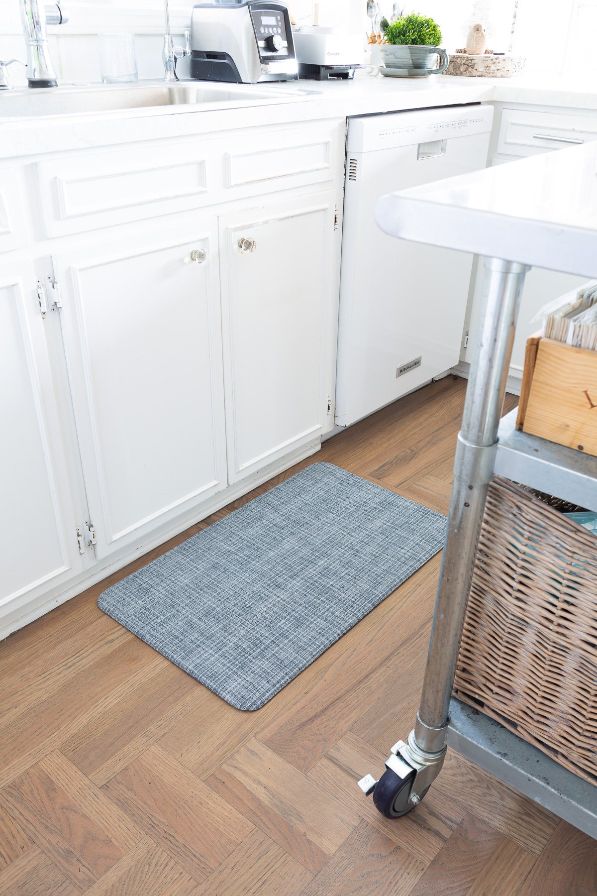 Lucky Brand wellness mat in blue weave in front of a kitchen sink.