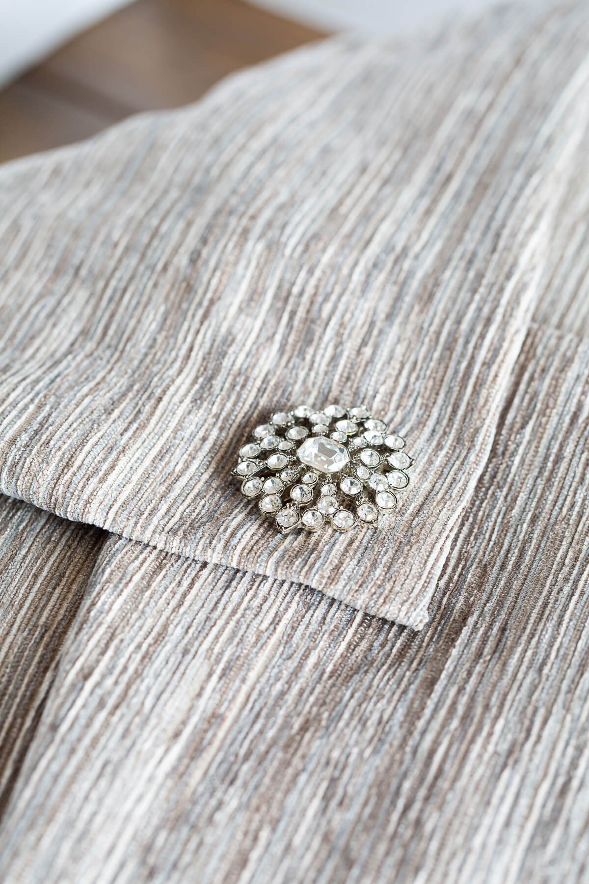 close up of a no zipper pillow cover to make with a pretty pin embellishment.