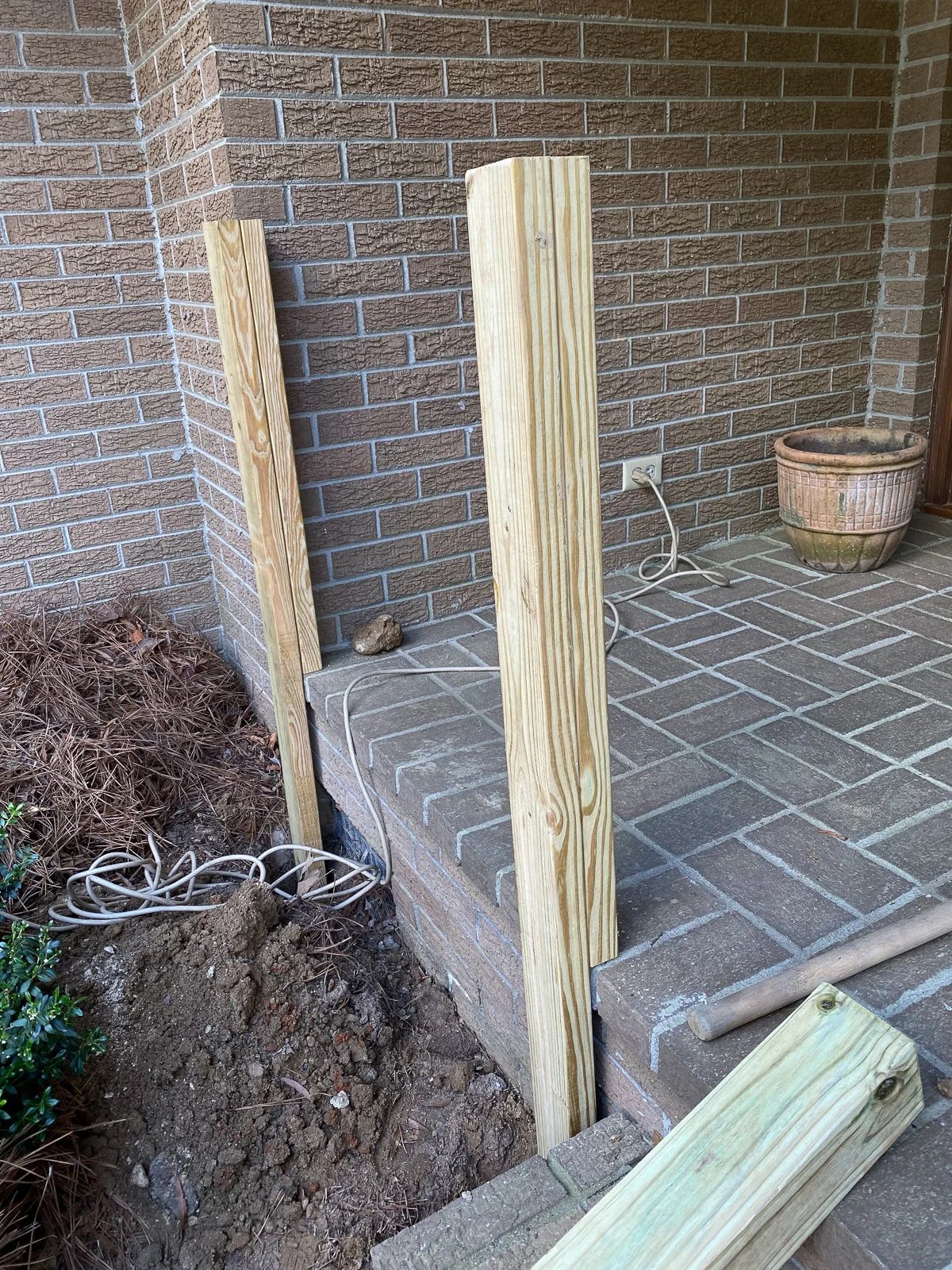 brick porch railing posts being installed