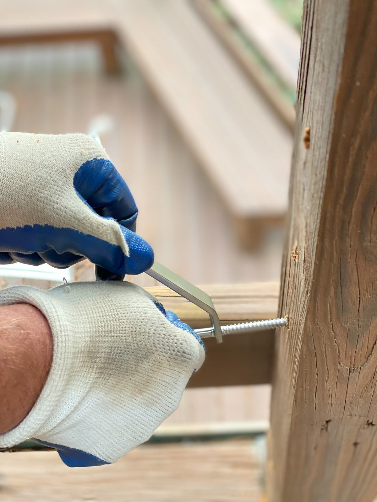 Deck Man cable railing system screws being turned into a wood post.