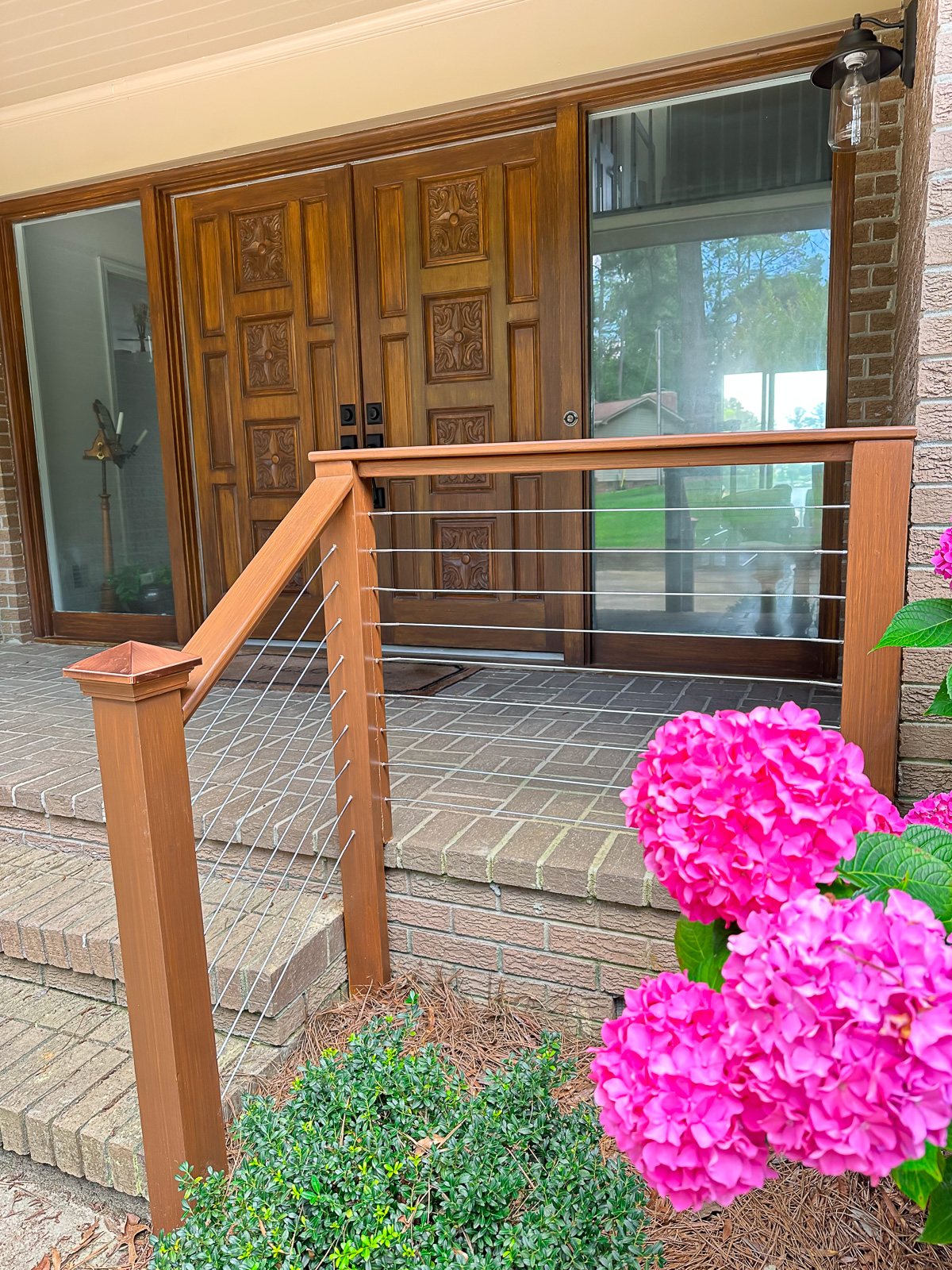 brick front porch railing being stained before cable railing sections added.