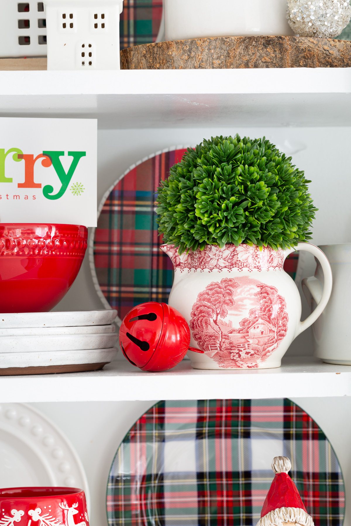 A mix of Christmas decor items styled on open shelves in a kitchen.