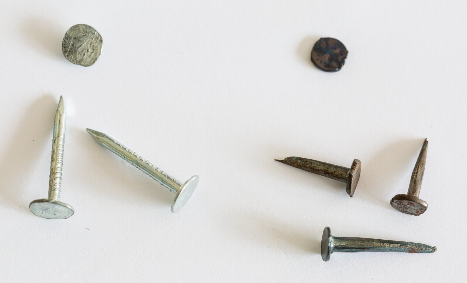 Flat head nails and carpet tacks used to construct a wood wine crate recipe card holder.