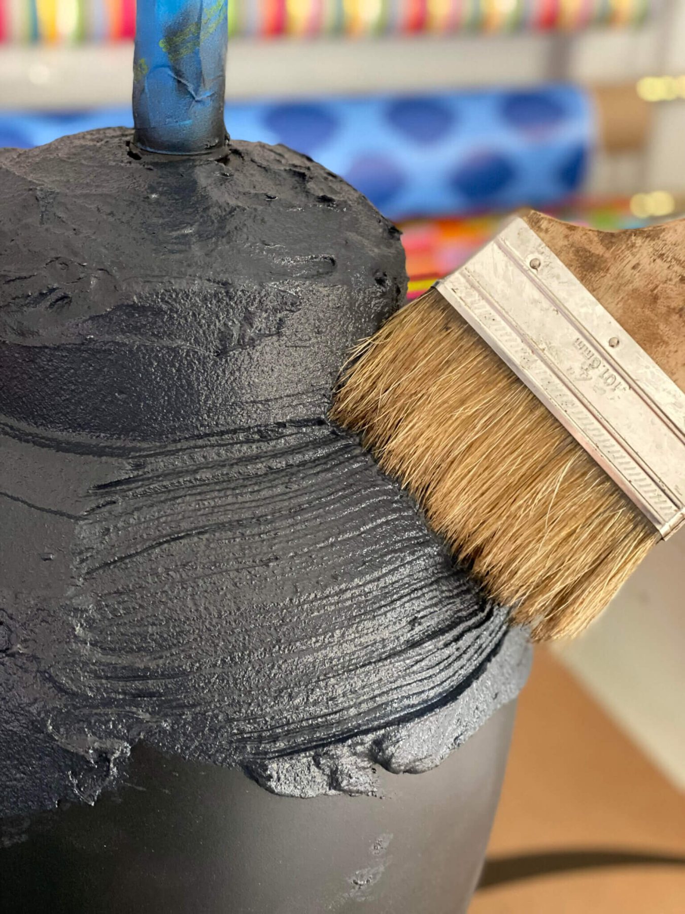 brushing on concrete patch mixed with black paint to a lamp base.