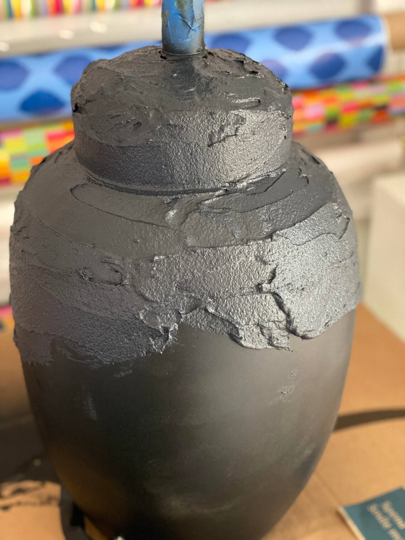 Textured paint being added to a table lamp base.