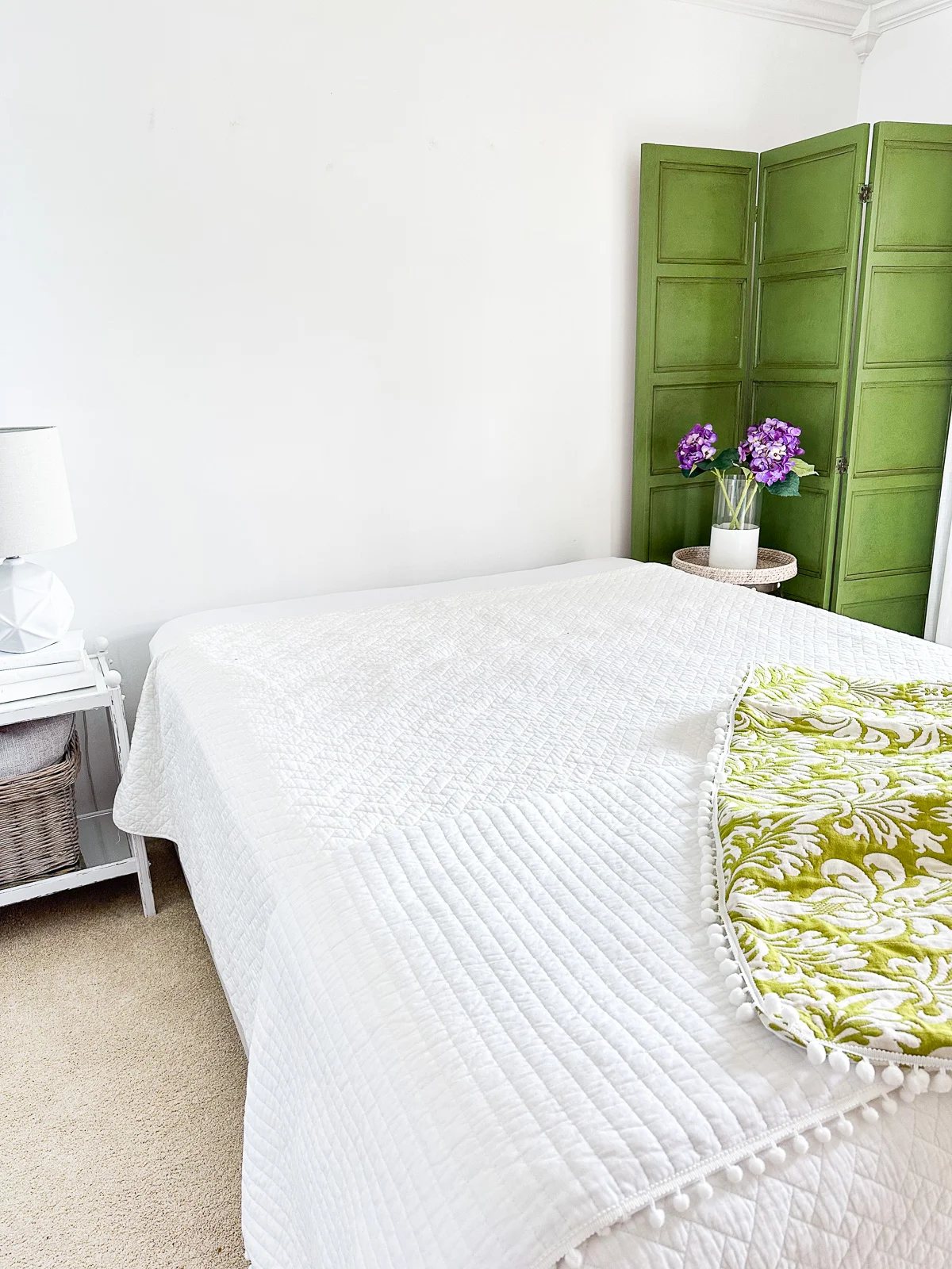Queen size upholstered bed frame without a headboard in a bedroom.