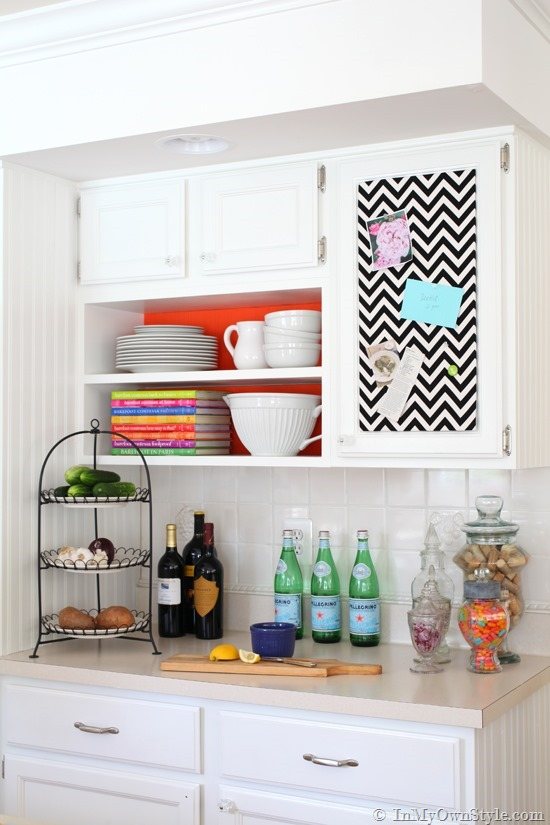 Accent color backdrop made using paper covered cardboard inserts in open kitchen shelving