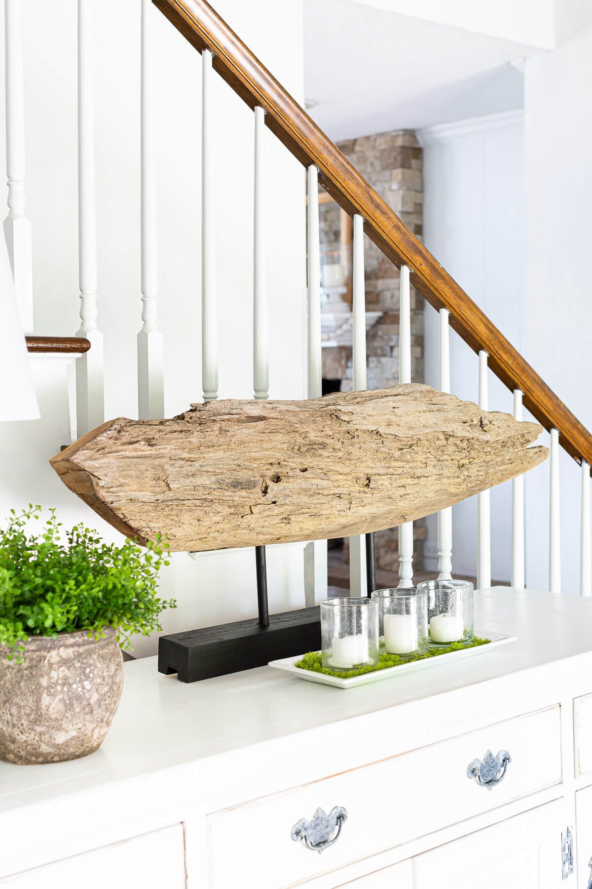 driftwood sculpture on stand on a foyer sideboard