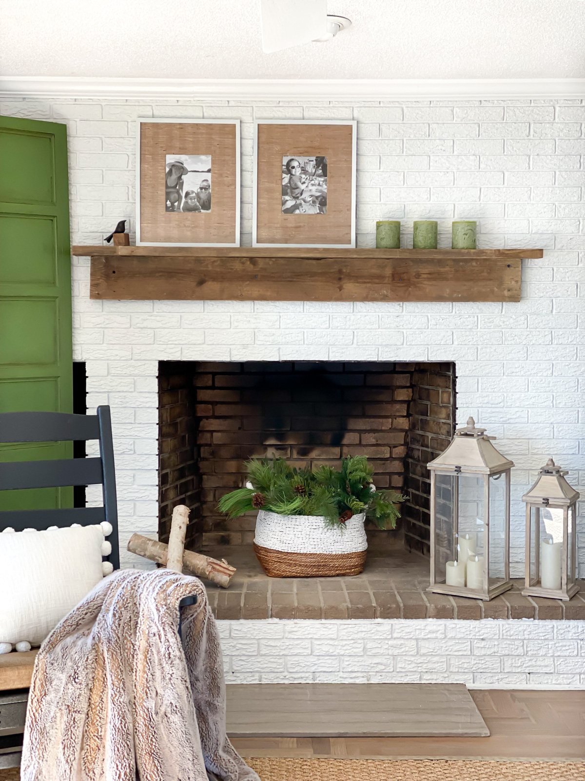 Living room with white brick fireplace wall and reclaimed wood DIY mantel