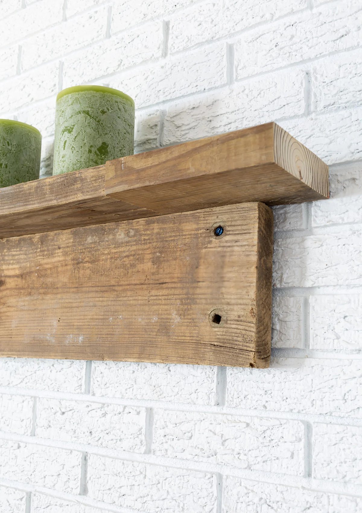 close up side view of DIY fireplace mantel made with two reclaimed wood boards.