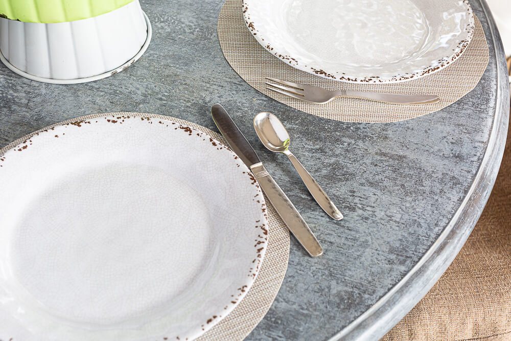 no sew round woven placemats with brunch plates on them on a round faux painted table.